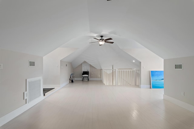 additional living space with lofted ceiling, visible vents, and wood finished floors