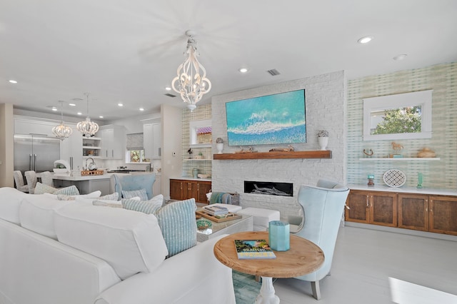 living area with recessed lighting, a fireplace, a notable chandelier, and visible vents