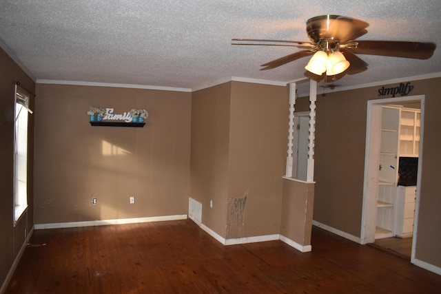 empty room with dark wood-type flooring, ornamental molding, and a textured ceiling