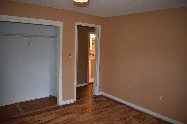 unfurnished bedroom with hardwood / wood-style floors and a closet