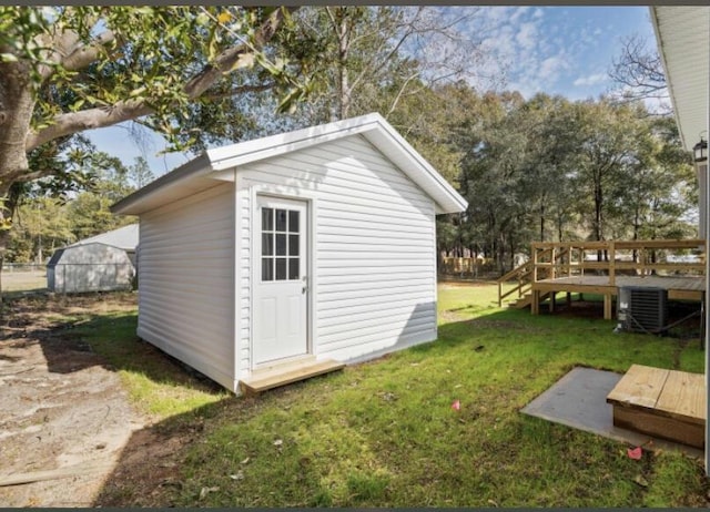 view of outdoor structure featuring a yard and central air condition unit