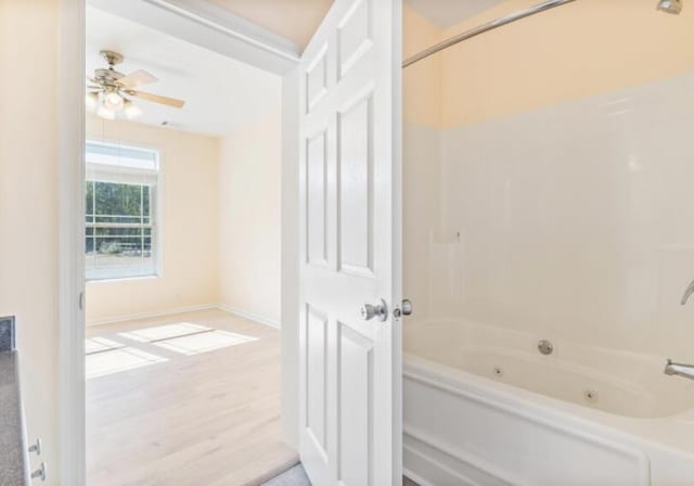 bathroom with ceiling fan, shower / tub combination, and wood-type flooring