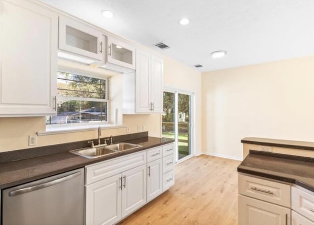 kitchen with white cabinetry, light hardwood / wood-style floors, dishwasher, and sink