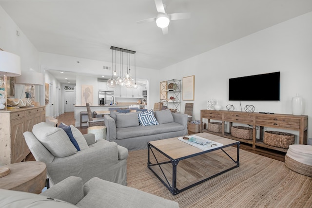 living room with light hardwood / wood-style flooring and ceiling fan