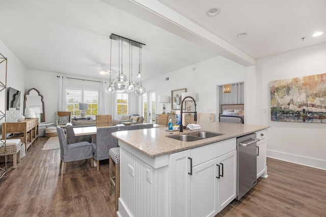 kitchen featuring pendant lighting, white cabinetry, an island with sink, dishwasher, and sink