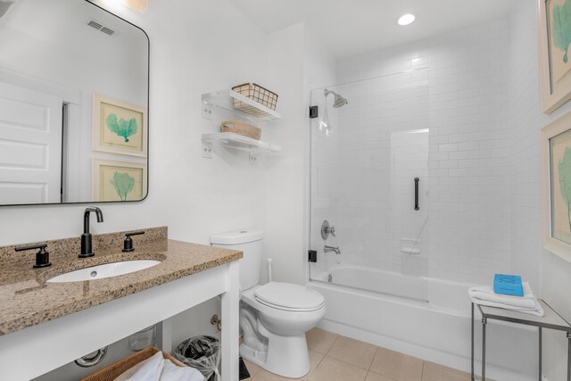 full bathroom featuring tiled shower / bath combo, vanity, tile patterned floors, and toilet