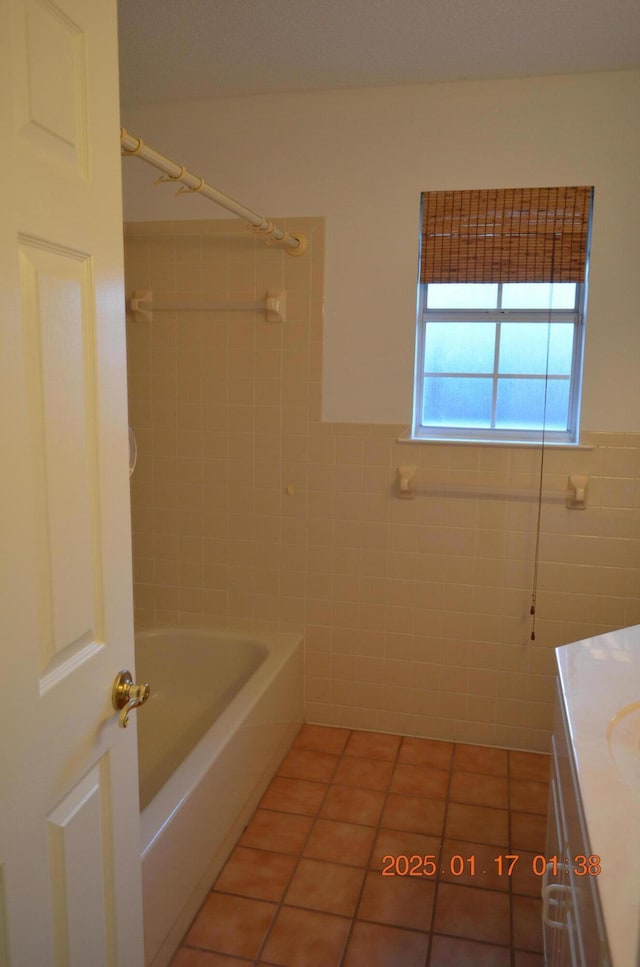 bathroom with tile walls, vanity, tile patterned floors, and tiled shower / bath