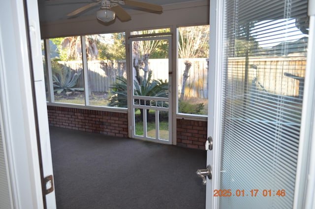 unfurnished sunroom with ceiling fan