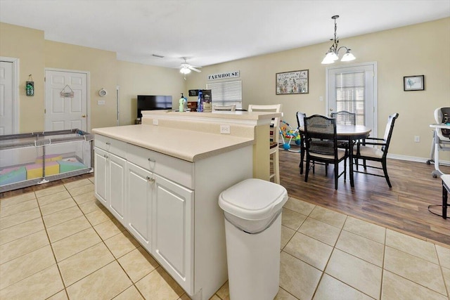 762 Shady St, Fort Walton Beach, FL 32547 - kitchen featuring light tile patterned flooring, ceiling fan with notable chandelier, pendant lighting, white cabinets, and a center island