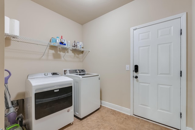 clothes washing area with light tile patterned floors and washing machine and clothes dryer