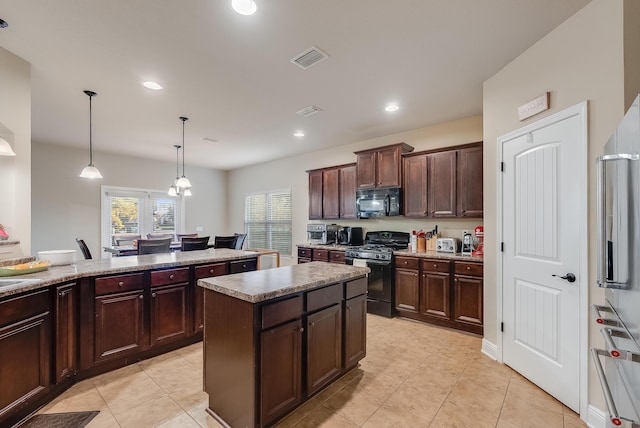 kitchen with light tile patterned floors, black appliances, dark brown cabinets, pendant lighting, and a center island