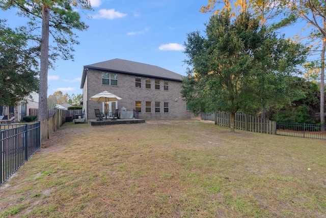 rear view of property with a lawn and a patio area