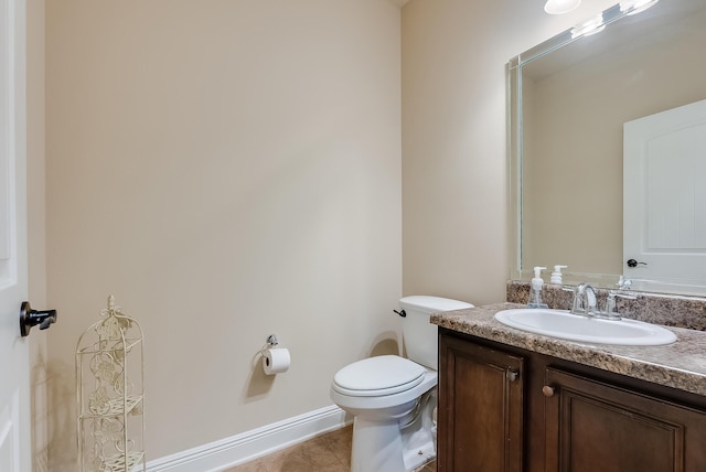 bathroom with toilet, tile patterned floors, and vanity