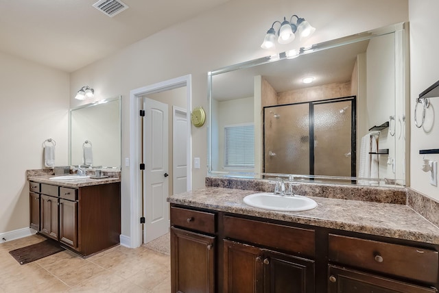 bathroom with a shower with shower door, vanity, and tile patterned flooring