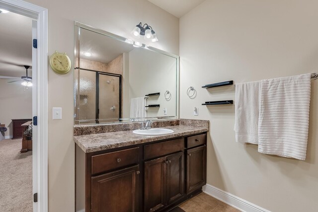 bathroom with ceiling fan, vanity, tile patterned flooring, and a shower with door