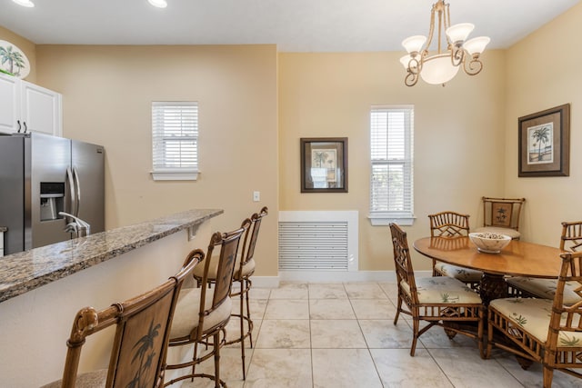 tiled dining room with a wealth of natural light and a chandelier