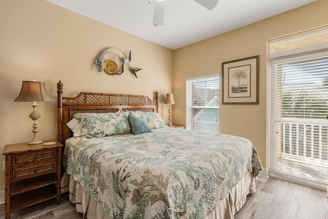 bedroom with ceiling fan, multiple windows, and hardwood / wood-style floors