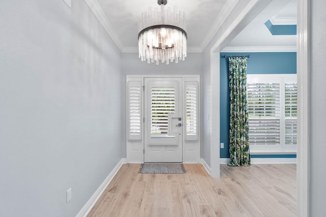 foyer with crown molding, a notable chandelier, and light wood-type flooring