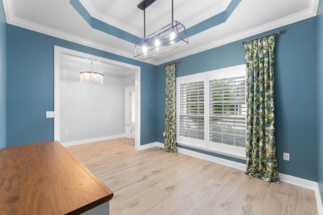 unfurnished dining area featuring crown molding and a raised ceiling