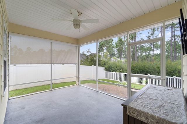 unfurnished sunroom featuring ceiling fan