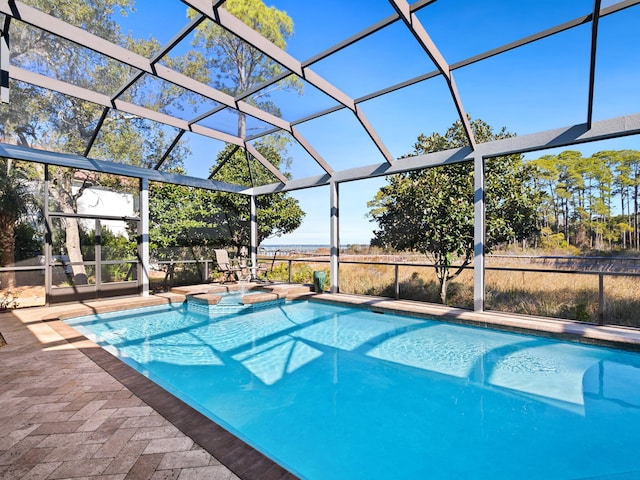 view of swimming pool featuring a patio area, an in ground hot tub, and glass enclosure