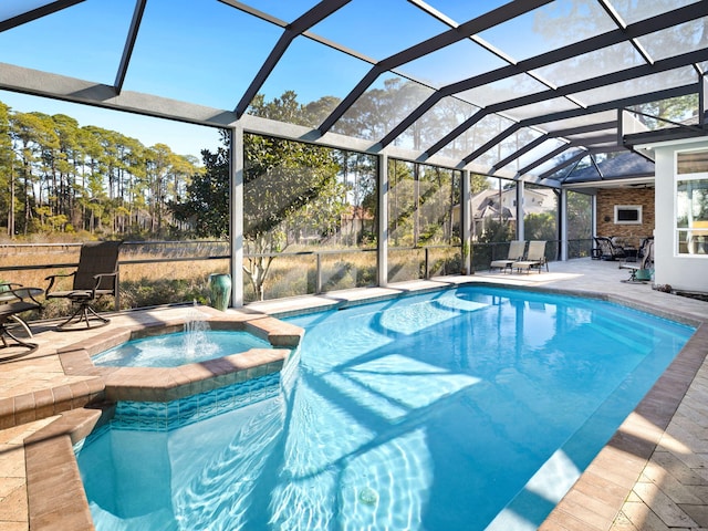 view of pool featuring a patio area, an in ground hot tub, pool water feature, and glass enclosure