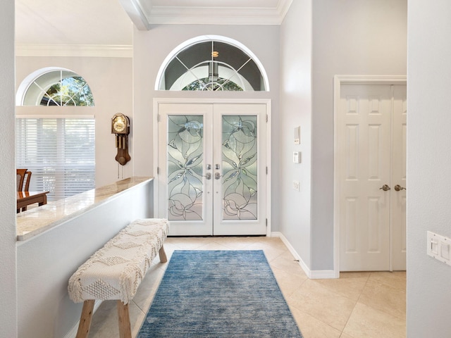 entrance foyer with ornamental molding, light tile patterned floors, and french doors