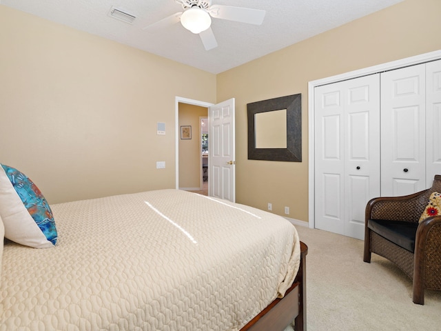 bedroom with light carpet, a closet, and ceiling fan