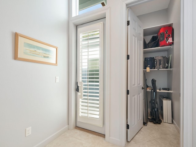 doorway to outside with light tile patterned floors