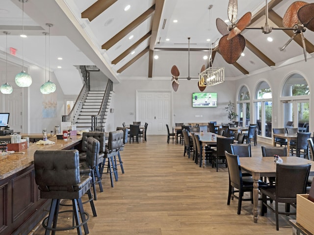 dining area featuring beamed ceiling, light hardwood / wood-style floors, and high vaulted ceiling