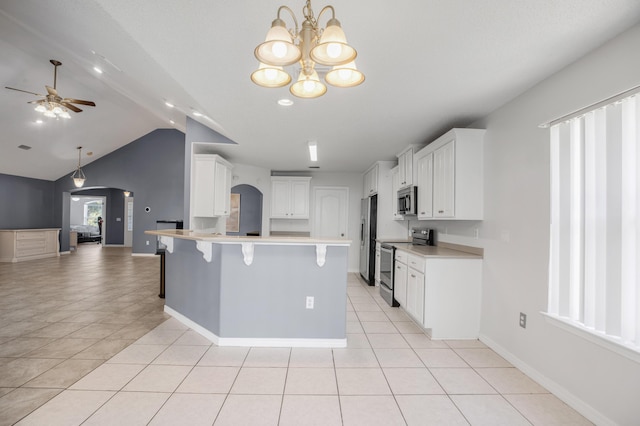 kitchen with white cabinetry, appliances with stainless steel finishes, a kitchen bar, and light tile patterned floors