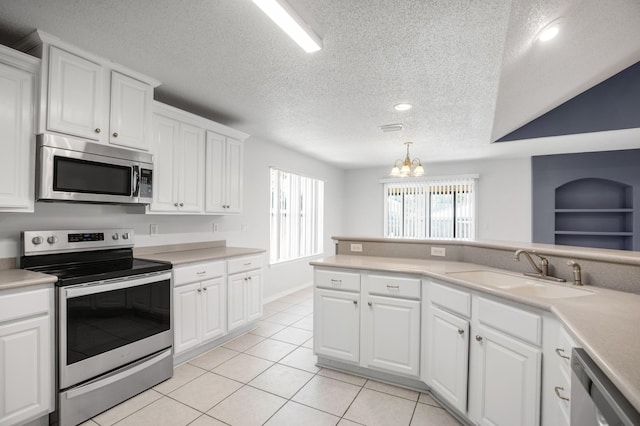 kitchen featuring white cabinets, hanging light fixtures, appliances with stainless steel finishes, and sink