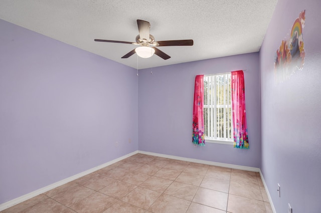 tiled spare room with a textured ceiling and ceiling fan