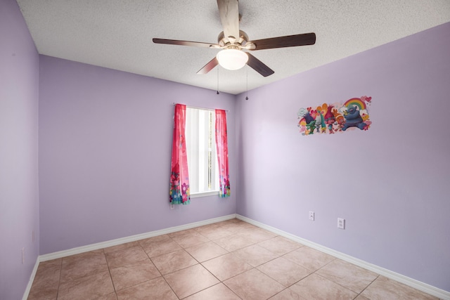 tiled spare room featuring ceiling fan and a textured ceiling