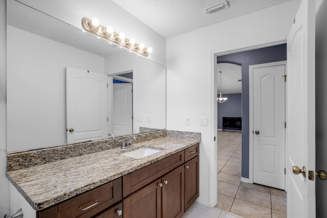 bathroom featuring a textured ceiling, vanity, and tile patterned flooring