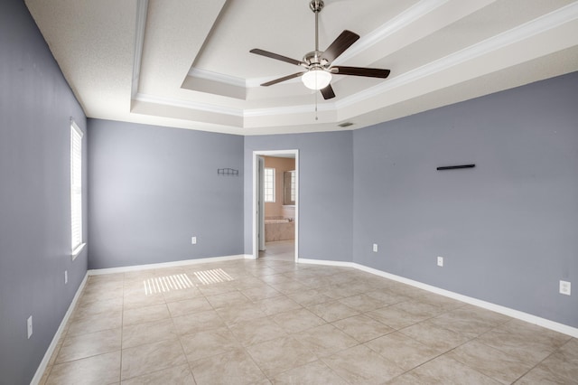 tiled spare room with ceiling fan, crown molding, and a raised ceiling