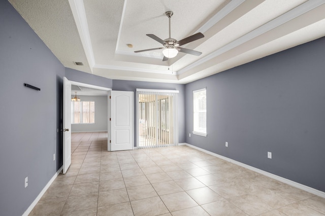 unfurnished bedroom featuring a tray ceiling, a textured ceiling, ceiling fan, and light tile patterned floors