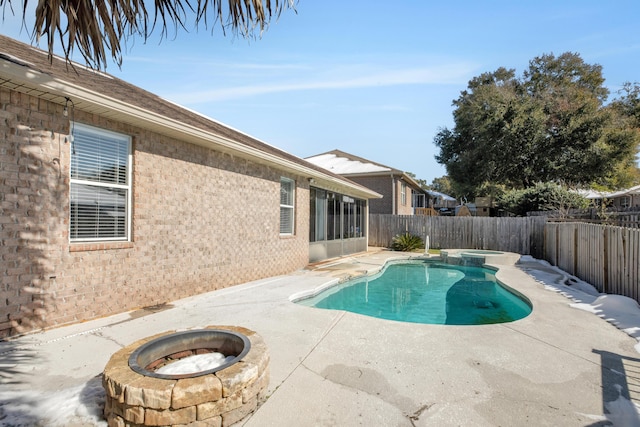 view of swimming pool with an in ground hot tub, a patio area, and an outdoor fire pit