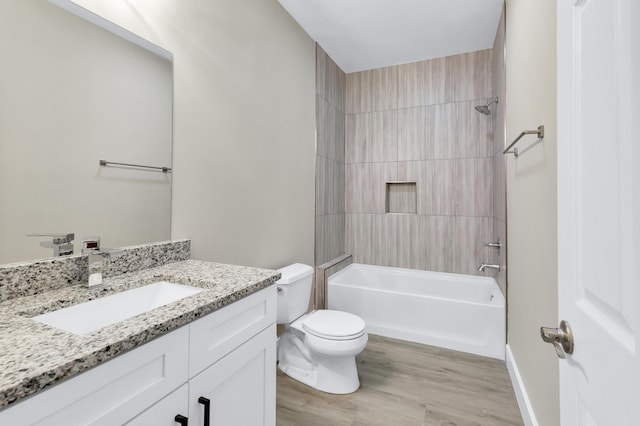 full bathroom with tiled shower / bath combo, vanity, hardwood / wood-style flooring, and toilet