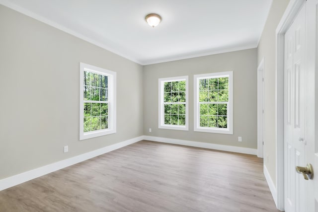 unfurnished room featuring crown molding and light wood-type flooring