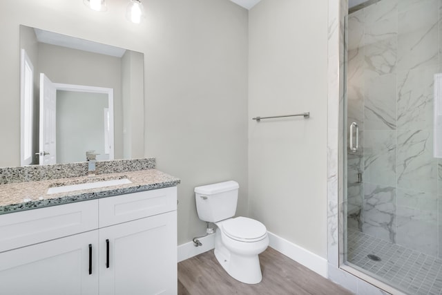 bathroom with walk in shower, vanity, toilet, and wood-type flooring