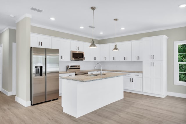 kitchen with appliances with stainless steel finishes, sink, pendant lighting, and white cabinets