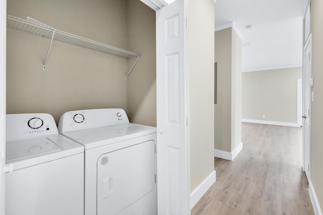 laundry area with washer and dryer and light wood-type flooring