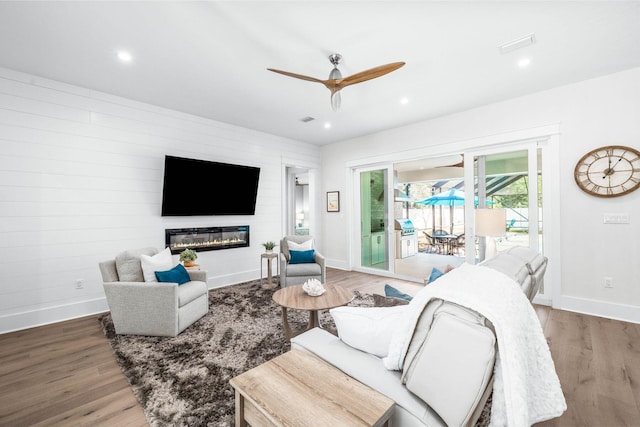 living room with ceiling fan and wood-type flooring