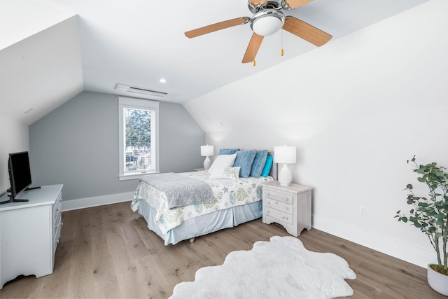 bedroom featuring ceiling fan, light wood-type flooring, and vaulted ceiling