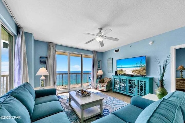 living room with ceiling fan and a textured ceiling