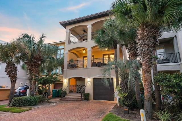 mediterranean / spanish home with ceiling fan, a balcony, and a garage