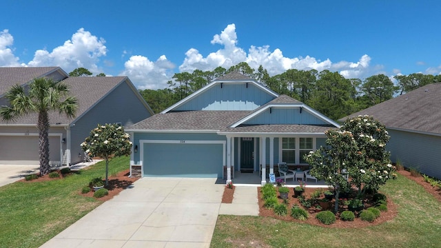 view of front of house with a garage, a front lawn, and covered porch