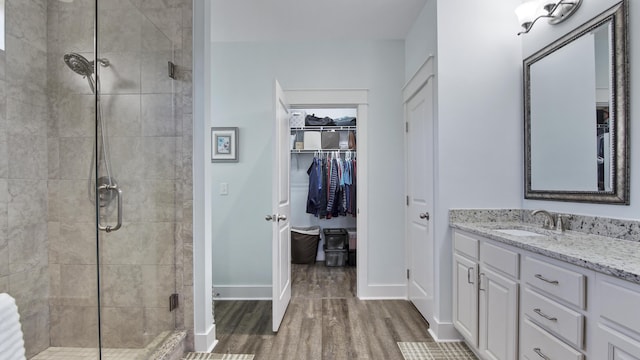 bathroom with vanity, hardwood / wood-style floors, and a shower with shower door