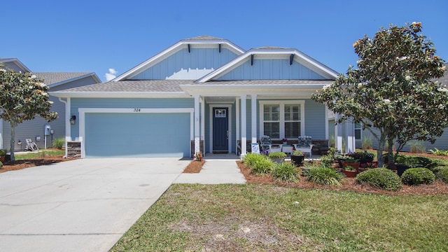 view of front of property with a garage, covered porch, and a front yard